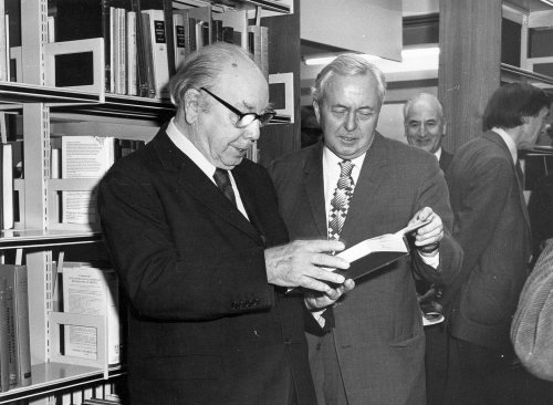 Priestley and Harold Wilson looking at book by shelves in new J.B. Priestley Library 